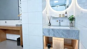 A modern bathroom with a vanity, mirror, and built-in shelves. - Qiqiaowu Hotel Songjiazhuang Station (Beijing)