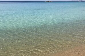 A clear view of a beach with shallow water, a distant rocky outcrop, and a small island. - La Maison Arche (Galatina)