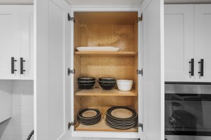 A kitchen cabinet with shelves containing bowls, plates, and a sink. - Cholla Retreat in the Heart of Downtown Phoenix (Phoenix)