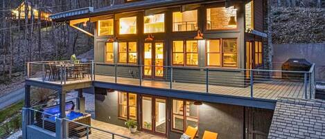 Une maison moderne à plusieurs étages, dotée d’un balcon, d’un espace salon extérieur et d’une piscine.