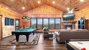 A cozy room with a pool table, a sofa, and a fireplace. - Amazing Mountain Views | Indoor Pool | Game Room (Sevierville)