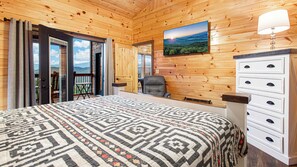 A room with a bed, a desk, a chair, a dresser, and a view of the outdoors. - Amazing Mountain Views | Indoor Pool | Game Room (Sevierville)
