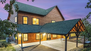 A two-story wooden house with a covered patio area. - Amazing Mountain Views | Indoor Pool | Game Room (Sevierville)