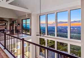 A high-rise building with large windows offering city views, a balcony with a railing, and a modern interior design. - Incredible Views | Heated Pool | Gourmet Kitchen (Sevierville)