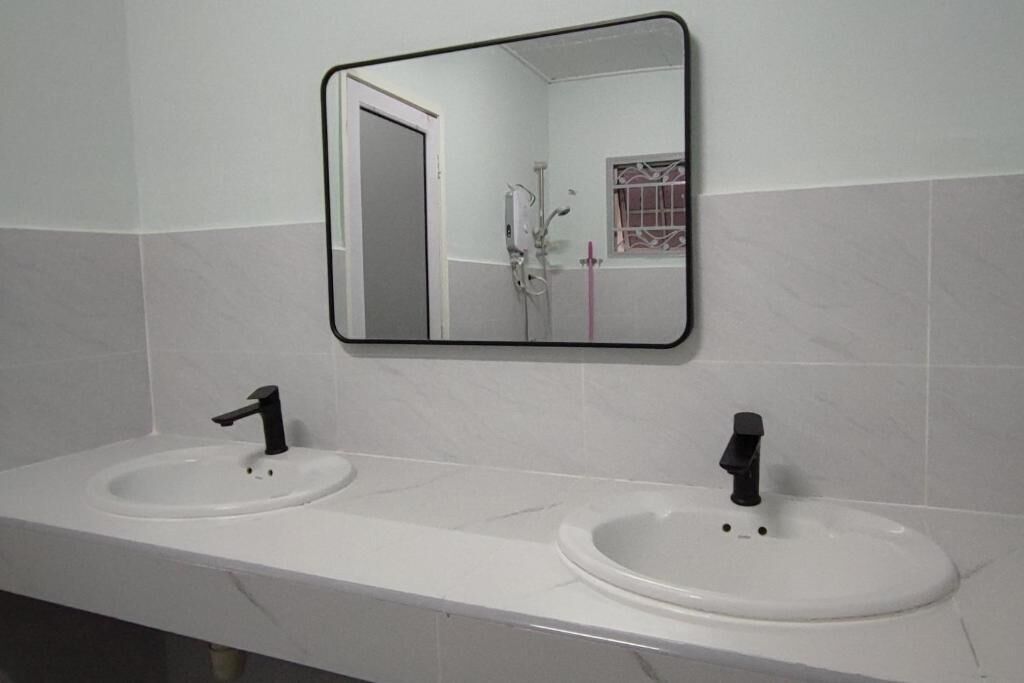 Ein Badezimmer mit zwei Waschbecken, einem Spiegel und einer Dusche.