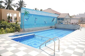 A swimming pool with a tiled deck and a mural of marine life.