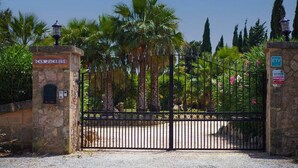 A gated entrance with a stone wall, a metal gate, and a sign that reads 'CAN JACOBUS.' - Villa Jacobus (Pollença)