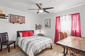 A bedroom with a bed, a desk, a chair, a bookshelf, a ceiling fan, and a picture on the wall. - Peaceful 3BR/1BA Home near DT and Hiking Serene (El Paso)