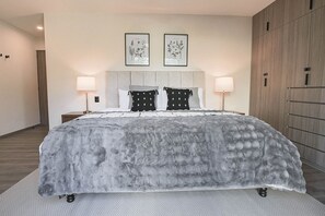 Una camera da letto moderna con un letto grande, due luci a parete e un armadio.