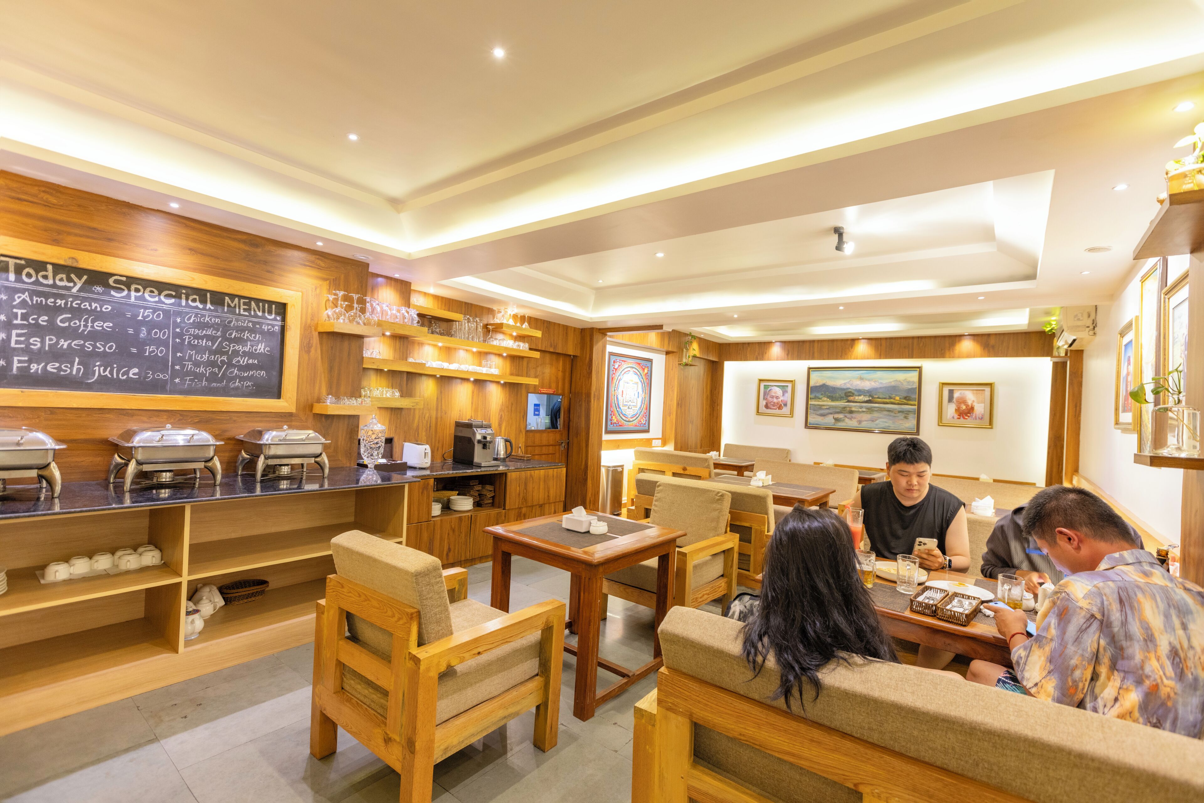 A restaurant with wooden furniture, a chalkboard menu, and various food and drink dispensers.
