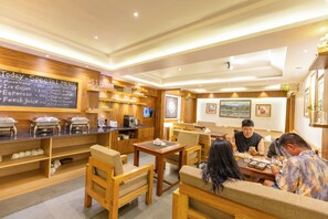 A restaurant with wooden furniture, a chalkboard menu, and various food and drink dispensers. - 14 LUXE By Mums Home (Kathmandu)