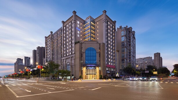 Un hôtel de grande hauteur, doté d’une entrée imposante, de nombreux étages et d’une vaste façade en verre.