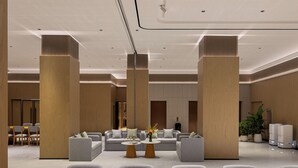 Un hall d’entrée moderne avec des canapés, des fauteuils et un comptoir d’accueil.
