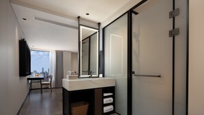 Une salle de bain moderne avec un grand miroir, un lavabo et une douche.