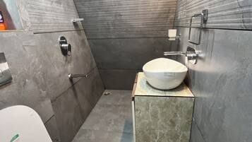 Een badkamer met toilet, wastafel en douche.