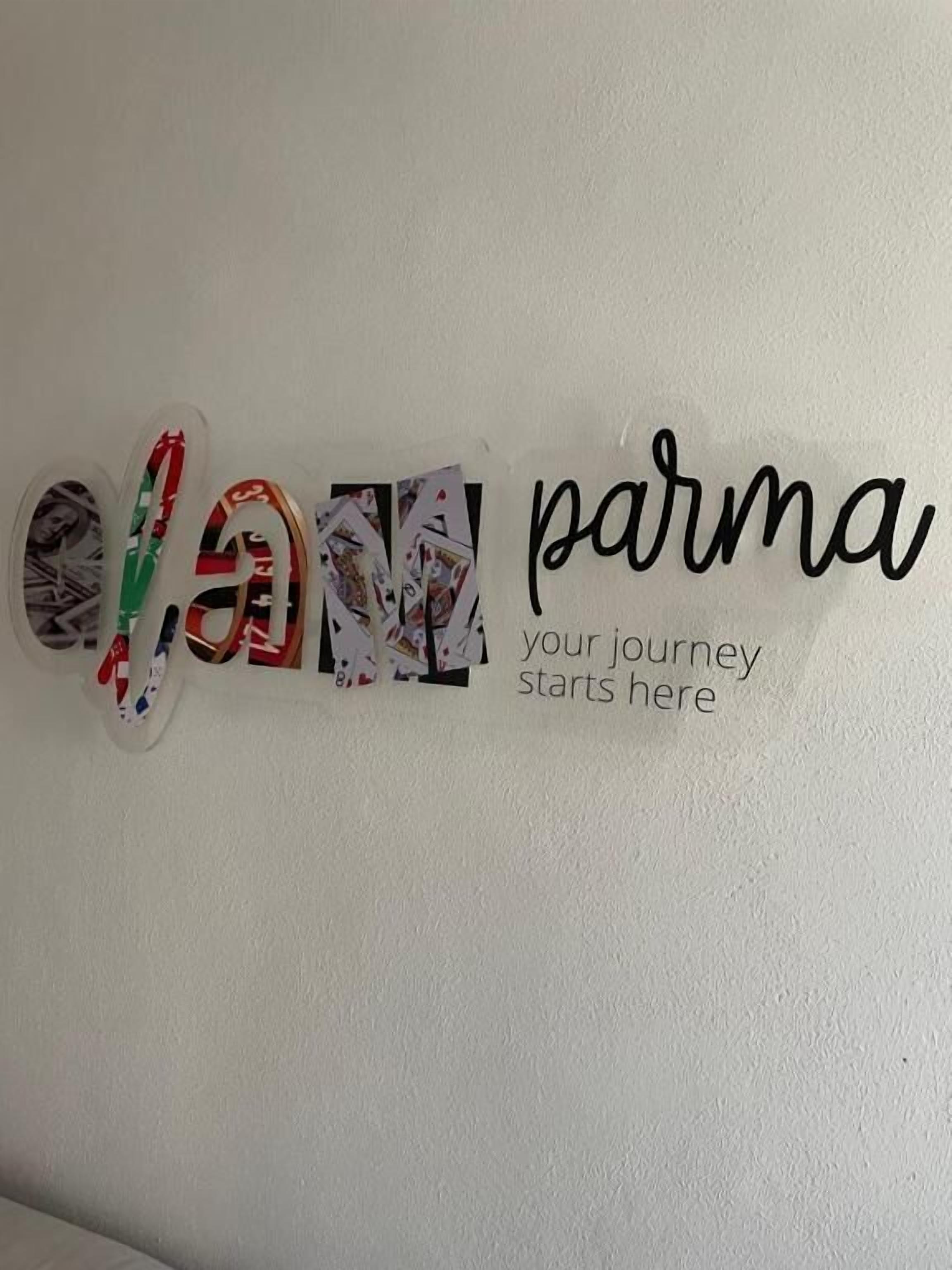A wall with a decorative sign that reads 'OLAN PARMA your journey starts here.'