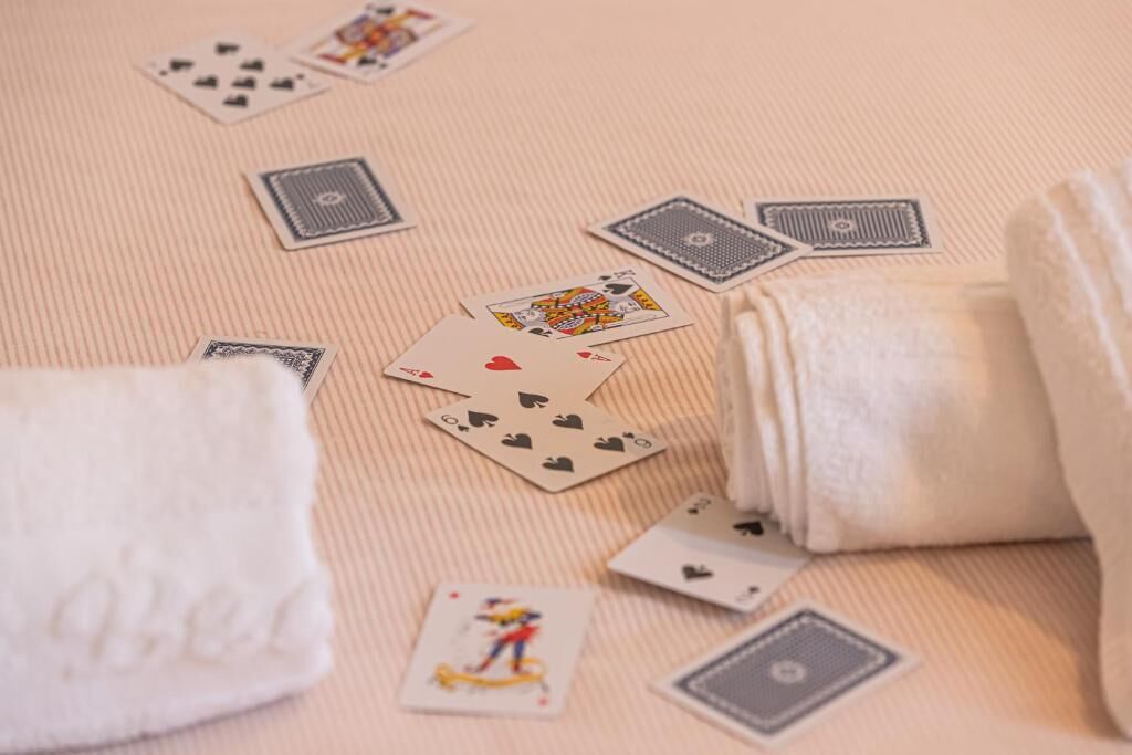 A card game setup on a textured surface with a white towel and a plush toy.