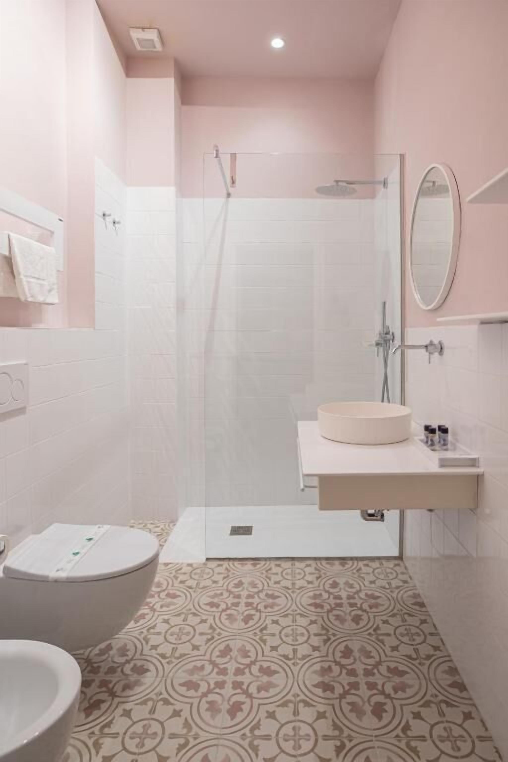 Une salle de bain avec douche, toilettes et lavabo.
