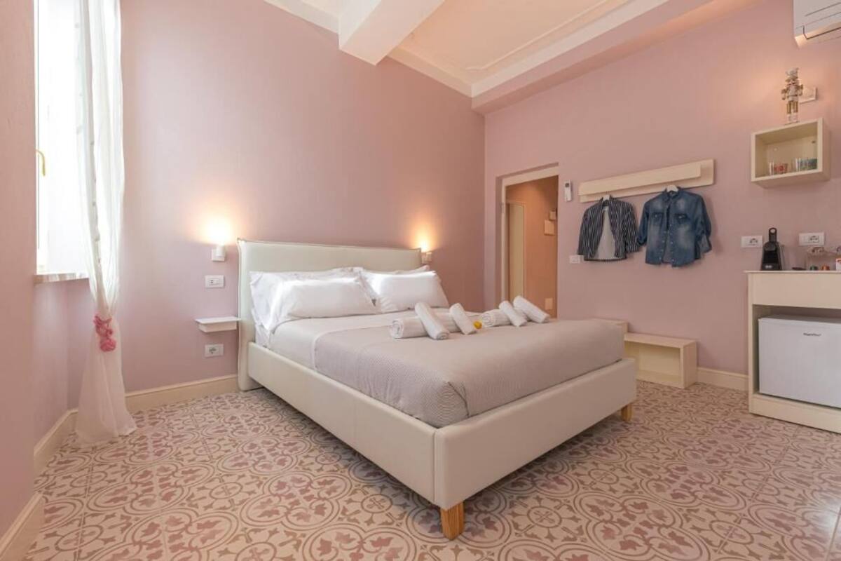 A bedroom with a bed, bedside tables, a wardrobe, and a mirror.