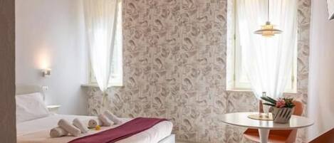 Ein Schlafzimmer mit einem Bett, einem kleinen Tisch und einem Stuhl.