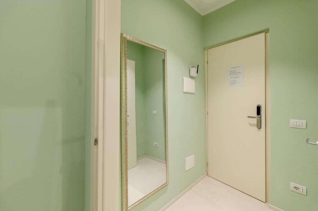 Un pasillo con una puerta y un espejo.