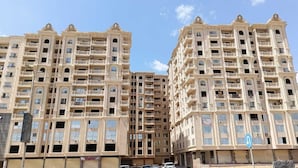 Um hotel com vários andares, varandas, janelas amplas e céu claro.