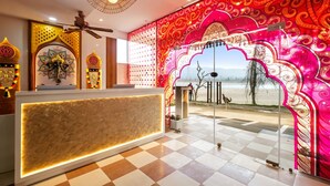 A reception area with a checkered floor, a reception desk, decorative wall patterns, and a view of the outdoors. - The Neeraj Ganga Rani Mahal (Rishikesh)