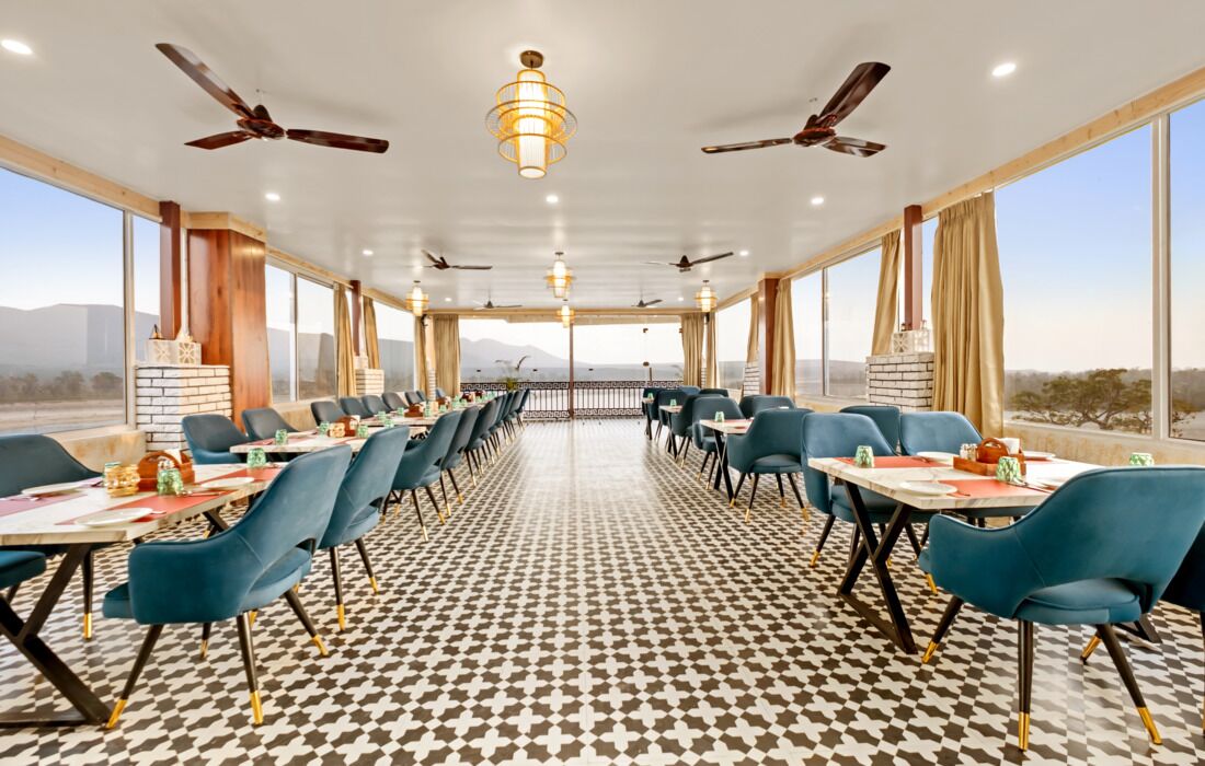 A long dining table with chairs, ceiling fans, and a patterned floor.