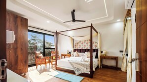 A bedroom with a four-poster bed, wooden flooring, a balcony with chairs, and a view of the outdoors. - The Neeraj Ganga Rani Mahal (Rishikesh)