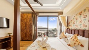 A hotel room with a bed, a TV, a wardrobe, and a balcony with a view. - The Neeraj Ganga Rani Mahal (Rishikesh)