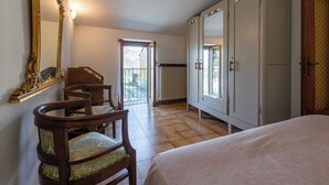 Ein Schlafzimmer mit einem Bett, einem Holzstuhl, einem großen Kleiderschrank und einem Spiegel.