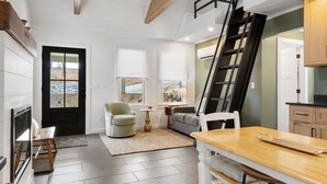 A spacious kitchen with a wooden table, a built-in oven, and a staircase leading to an upper level.