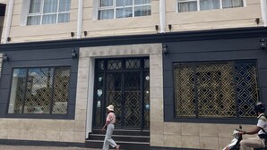 A multi-story building with a balcony, large windows, and a gated entrance. - Radama Hotel & Studios (Antananarivo)