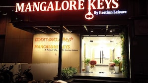 A hotel entrance with signage for 'MANGALORE KEYS By Bestinn Leisure' and a sign in a local language.