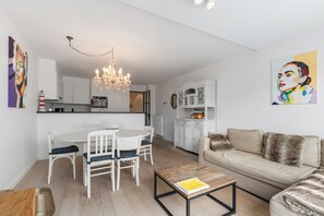 A modern living room with a dining area, a chandelier, a sofa, and a coffee table. - Dukdalf 20 0403 + G-2/17 (Nieuwpoort)