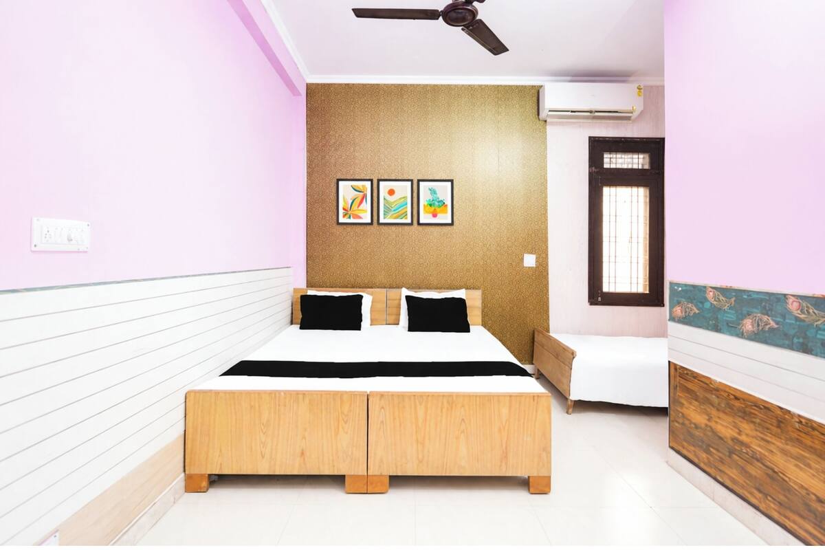A bedroom with a bed, a ceiling fan, a window, and a door.