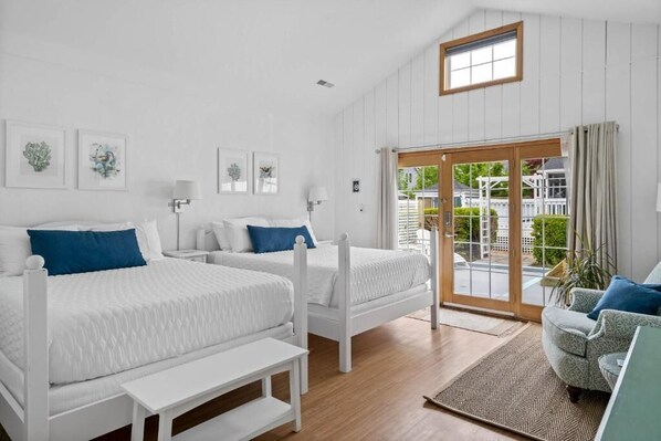 Un dormitorio con dos camas, un sofá, una ventana y vistas al exterior.