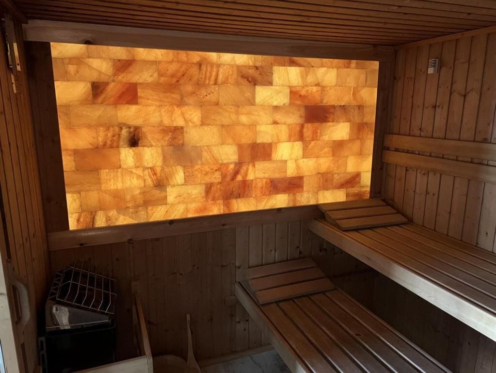 Un sauna avec des bancs en bois et un mur en bois.