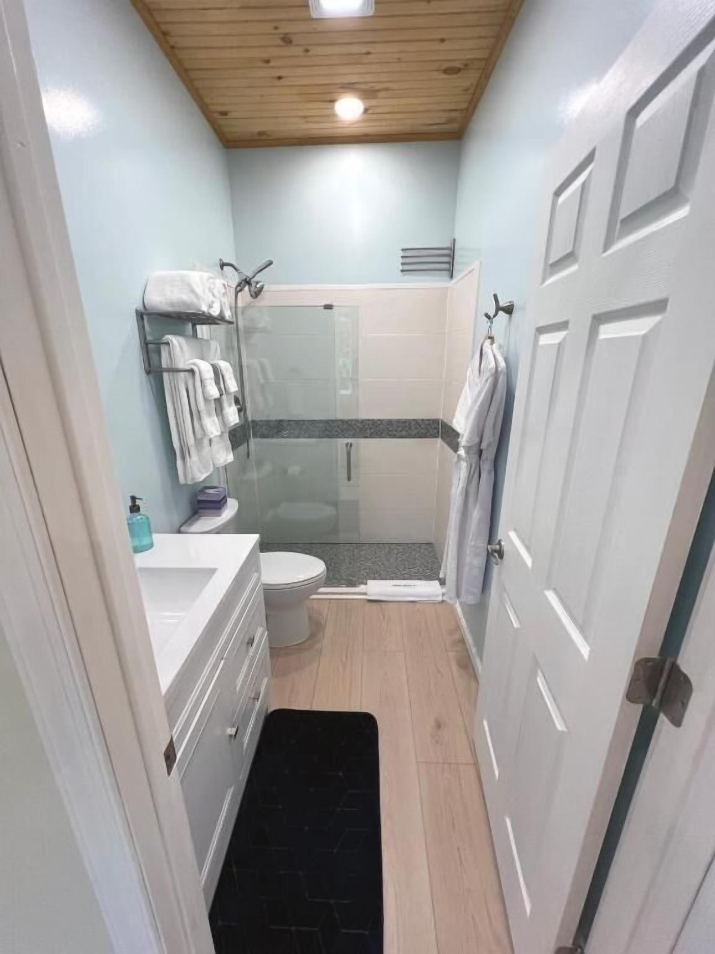 Une petite salle de bain comprenant une douche, des toilettes et un lavabo.