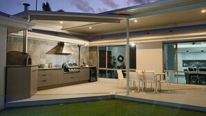 Cozinha moderna com forno embutido e área de refeições com cadeiras.