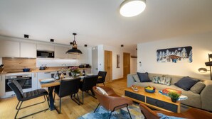 Una cocina moderna con comedor, sofá e imagen colgada en la pared.