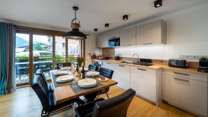Una cocina moderna con comedor, ventanas amplias y vistas al exterior.