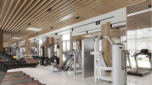 A modern gym with various exercise machines, a treadmill, and a large window providing natural light. - 1BR Apartment near VSIP – Pool & Gym (Thành phố Thủ Dầu Một)