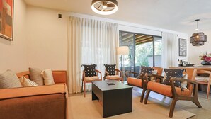 A modern living room with a sofa, chairs, a coffee table, and a dining area with a table and chairs. - Modern 3BR Pool & Gym in Nueva Escondida (San Miguel de Allende)
