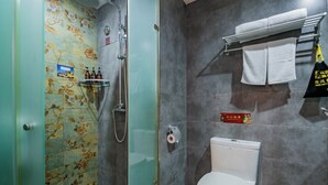 Une salle de bain avec douche, toilettes et une étagère contenant des articles de toilette.
