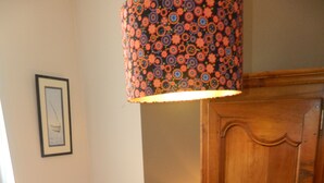 A small bedroom with a single bed, a wooden wardrobe, a framed picture on the wall, and a patterned lamp. - Nice little house in a good location to forget your car during the vacations. (Paris)
