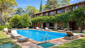 A swimming pool with lounge chairs, a stone building, and surrounding greenery. - Scappo in Umbria, Villa Maria (Panicale)