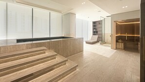 Un interior moderno con una escalera de piedra, un mostrador de recepción y una partición de vidrio.