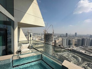 A rooftop pool with a glass barrier, a modern architectural design, and a cityscape view. - Binghatti Phantom (Dubai)