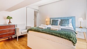 A bedroom with a bed, bedside tables, a dresser, and a potted plant. - Rooftop Apartment with Private Terrace (Lisboa)